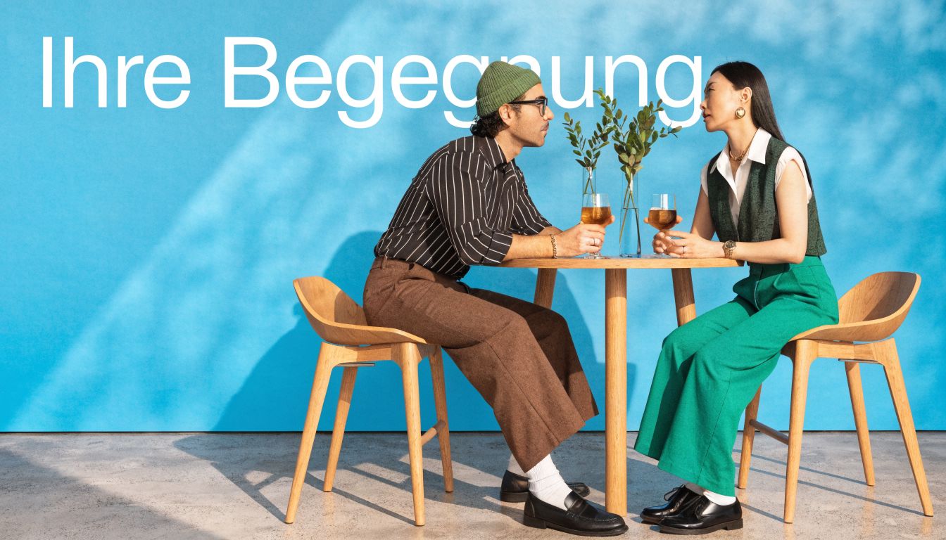 Ein stilvolles Paar sitzt in einem Restaurant an einem Tisch und genießt gemeinsam ein Getränk.